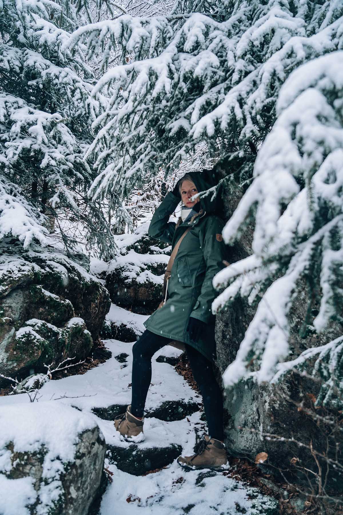 Frau im verschneiten Felswandergebiet Bayerischer Wald