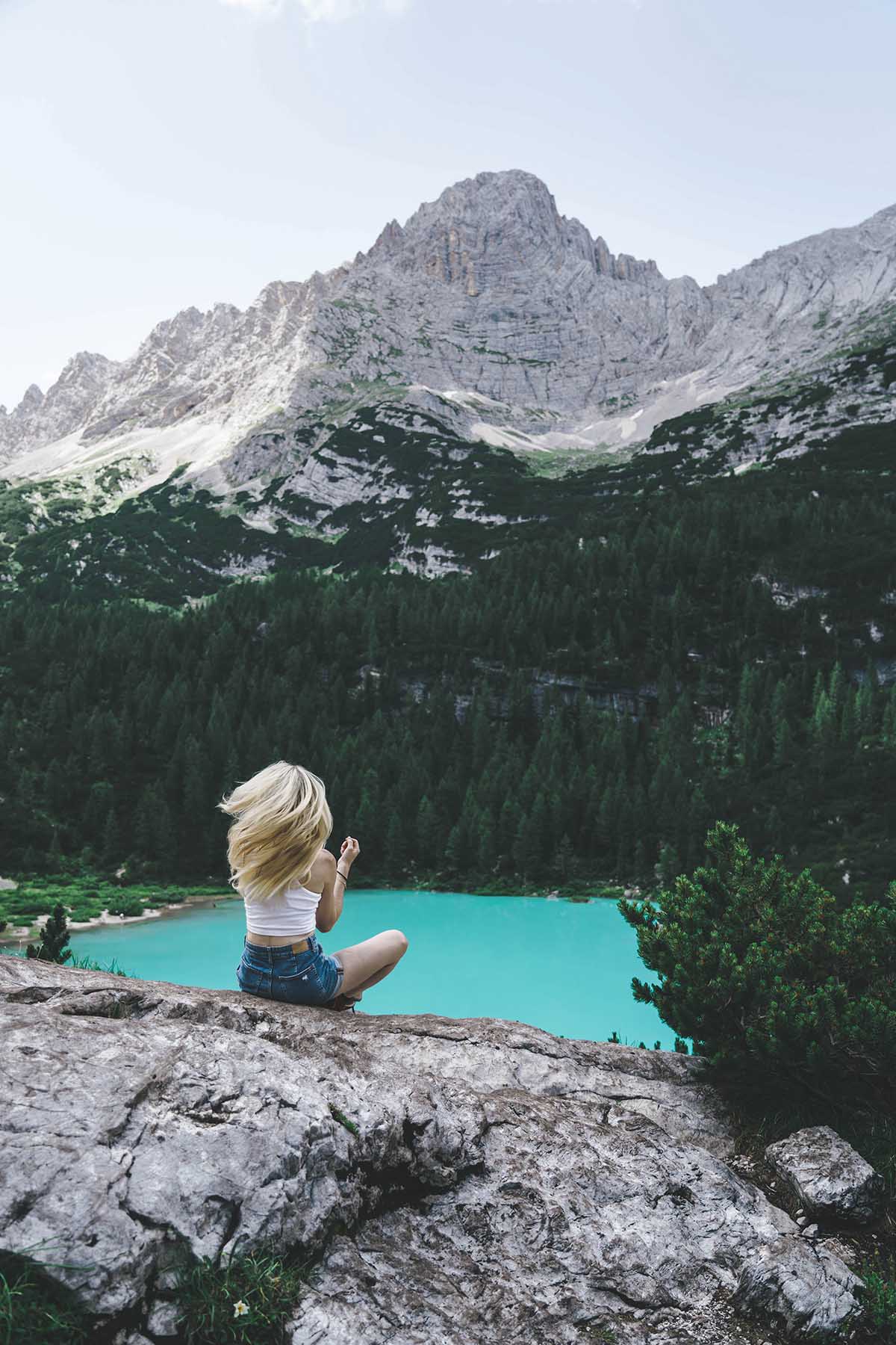 Frau sitzend am Sorapis See und Berge