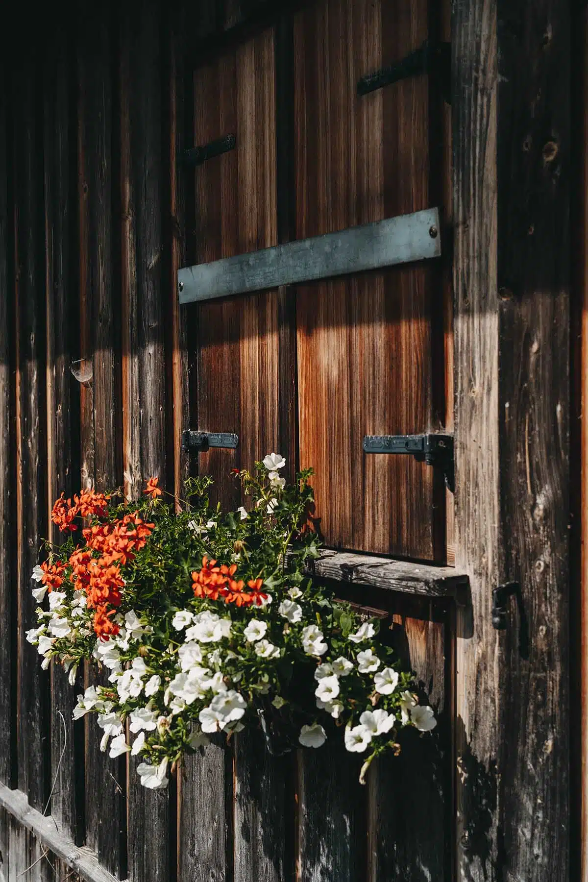 mit Blumen geschmücktes Bootshaus im Alpenvorland